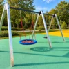 Stalowa huśtawka na plac zabaw z okrągłym bocianim gniazdem w kolorze niebiesko-czerwonym i siedziskiem płaskim